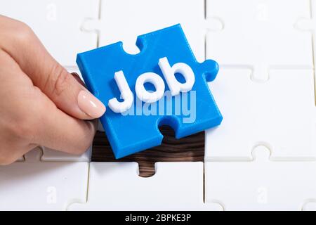 Angolo di Alta Vista della mano umana azienda lavoro blu Puzzle Foto Stock