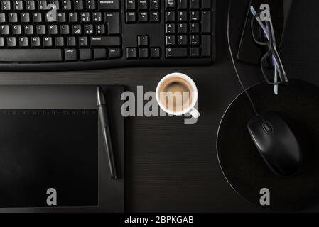 Nero totale scrivania con pc, tablet, oggetti personali e la tazza di caffè Foto Stock