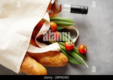 Negozi di generi alimentari freschi e vino in un tessuto riutilizzabile shopping bag per sostituire inquinanti di plastica su un sfondo di ardesia con spazio di copia Foto Stock