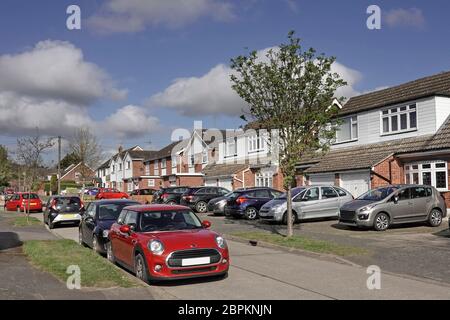 Zona residenziale parcheggio auto strada sobborgo in strada e case con auto sul prato originale giardino anteriore ora veicolo lastricato parco spazio Essex Inghilterra UK Foto Stock