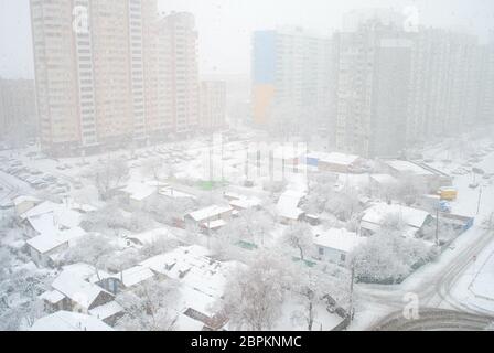 Nevicate invernali in zona residenziale con contrasto di urbano moderno appartamento edifici e la vecchia casa privata, Kiev, Ucraina Foto Stock