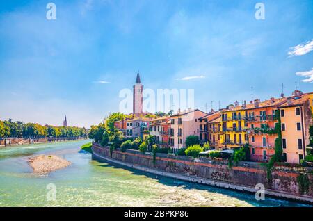 Città di Verona con edifici sul lungofiume dell'Adige, campanile Chiesa cattolica di Santa Anastasia, centro storico, cielo blu sfondo, Regione Veneto, Italia settentrionale Foto Stock