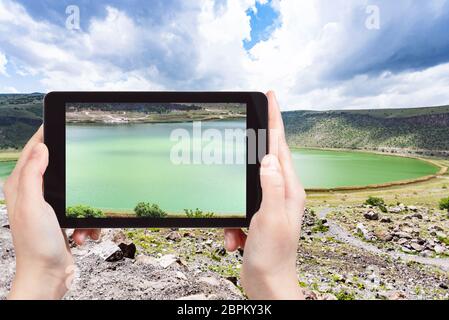 Concetto di viaggio - tourist fotografie di Narligol Crater Lake (lago Nar) nel campo geotermico in Aksaray Provincia di Cappadocia sullo smartphone in Turchia Foto Stock