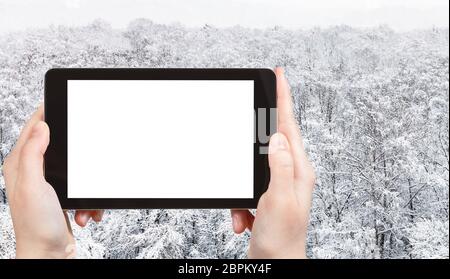 Concetto di viaggio - fotografie turistiche di vista panoramica di alberi innevati nel parco della città in inverno a Mosca su smartphone con ritaglio vuoto scr Foto Stock