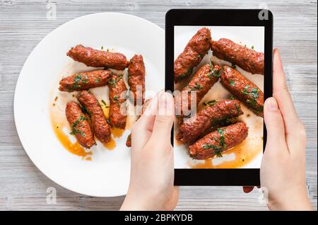 Concetto di viaggio - visitatore fotografie di cucina indiana di carni di montone Seekh Kabab (Hyderabadi Seekh) da macinata carni di agnello arrostito su spiedini tandoor su Foto Stock