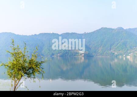 Fotografia di autunno colorato lago di montagna con cielo chiaro. Ampio angolo di paesaggio del lago di Pokhara a Kathmandu in Nepal. Vintage guardare film. Vacanza libera Foto Stock