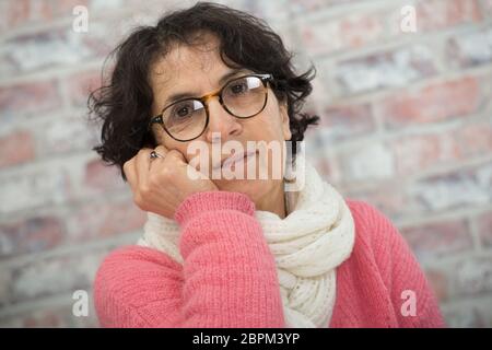 Ritratto di attraente senior brunette con un maglione rosa Foto Stock