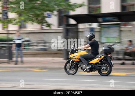 Belgrado, Serbia - 14 maggio 2020: Giovane uomo che cavalca una moto gialla sulla strada della città, in un colpo di scena e in movimento sfocato Foto Stock