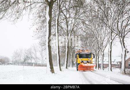 Carrello con spartineve rimuove la neve fuori strada ghiacciata in inverno Foto Stock