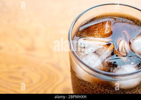 Primo piano vetro riempito con bevanda analcolica di cola gassata con cubetti di ghiaccio. Fuoco selettivo Foto Stock