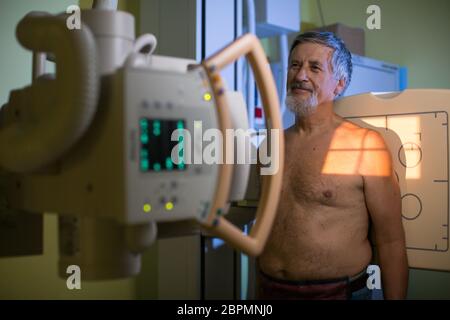 Il concetto di assistenza sanitaria - Senior paziente di sesso maschile sottoposti a un esame ai raggi X in un moderno ospedale Foto Stock