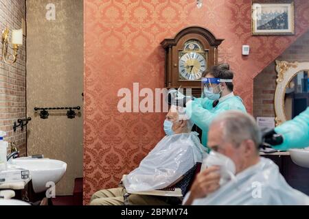 Roma, Italia. 18 maggio 2020. Un barbiere vestito con tuta protettiva come misura preventiva taglia i capelli di un uomo mentre le imprese riaprono a Roma, Italia durante l'emergenza Coronavirus (Covid-19) il 18 maggio 2020. (Foto di Davide Fracassi/Pacific Press/Sipa USA) Credit: Sipa USA/Alamy Live News Foto Stock