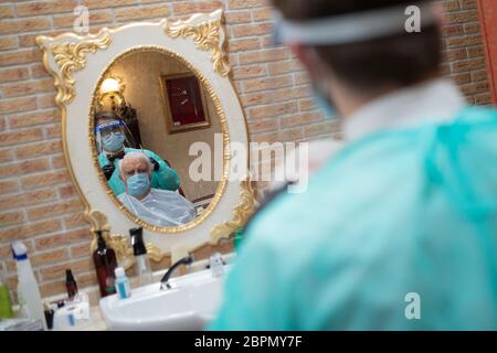 Roma, Italia. 18 maggio 2020. Un barbiere vestito con tuta protettiva come misura preventiva taglia i capelli di un uomo mentre le imprese riaprono a Roma, Italia durante l'emergenza Coronavirus (Covid-19) il 18 maggio 2020. (Foto di Davide Fracassi/Pacific Press/Sipa USA) Credit: Sipa USA/Alamy Live News Foto Stock