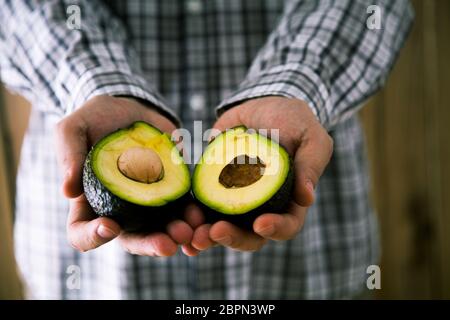 Lo chef con avocado. Uomo con fresca frutta avocado Foto Stock