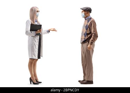 Foto di profilo a lunghezza intera di una dottoressa e di un paziente anziano che parla e indossa maschere protettive isolate su sfondo bianco Foto Stock