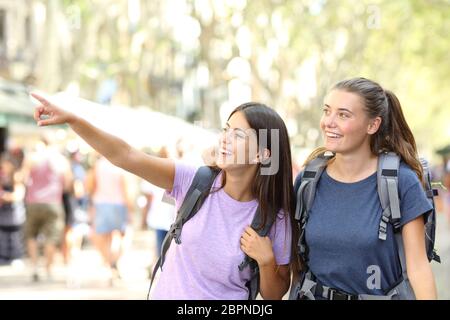 Felice backpacker visite di amici e punti di riferimento di puntamento in strada Foto Stock