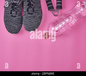 Coppia di nero sneakers con lacci su uno sfondo rosa, vista dall'alto, spazio di copia Foto Stock