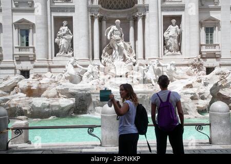 Pedoni, con maschere protettive, passeggiata in vista della Fontana di Trevi a Roma, Italia, martedì 19 maggio 2020. Negozi e ristoranti riaprono mentre l'Italia facilita ulteriormente Lockdown nella fase 2 Foto Stock