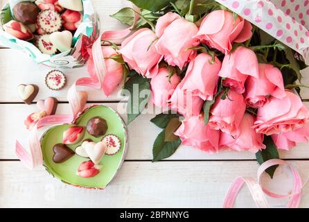 Mazzetto di lussureggianti e le rose rosa e cioccolatini colorati Foto Stock