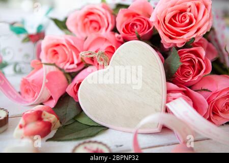 Mazzetto di lussureggianti e le rose rosa e un cuore con spazio di copia Foto Stock