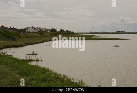 Fiume Adur estuario a Shoreham nel West Sussex, in Inghilterra. Con le case lungo la banca Foto Stock