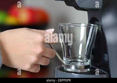 Close up ritratto di una donna mano che regge una tazza vuota in una macchina per il caffè Foto Stock