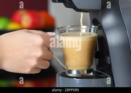 In prossimità di una donna mano che regge una tazza in una macchina per il caffè Foto Stock