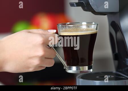 Close up ritratto di una donna mano che regge una tazza in una macchina per il caffè Foto Stock