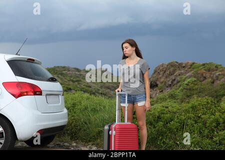 Frustrato pilota di auto in attesa di assistenza dopo la rottura con una tempesta in background Foto Stock