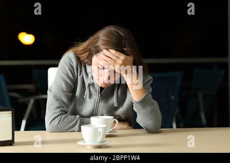 Triste teen lamentarsi dopo la pausa in un ristorante di notte Foto Stock