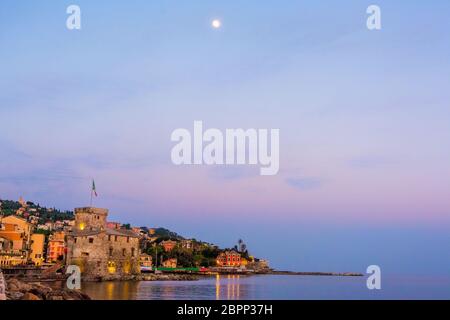 Panorama di un villaggio italiano con spazio per il testo e la luna in alto nel cielo - Rapallo - italia città copyspace sfondo notte tramonto Foto Stock