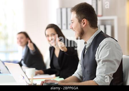 Dipendente fiero ricevere complimenti dai suoi colleghi in ufficio Foto Stock