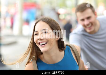 Funny paio di adolescenti in funzione verso la telecamera sulla strada Foto Stock