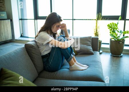 Triste depresso giovane donna pensierosa sentirsi male a casa Foto Stock