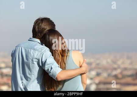 Vista posteriore ritratto di una coppia felice dating contemplando la città Foto Stock