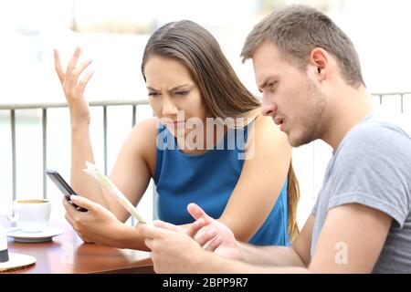 Confuso paio di turisti in cerca posizione seduti in un caffè Foto Stock