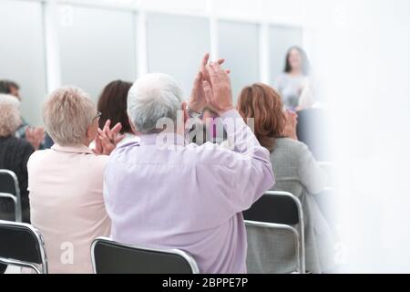 Vista posteriore di un anziano che ascolta una lezione Foto Stock