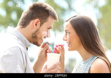 Vista laterale di una coppia felice cadere in amore e la condivisione di un drink Foto Stock