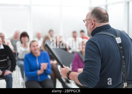 L'uomo caucasico maturo dà un discorso in riunione in ufficio aperto moderno Foto Stock