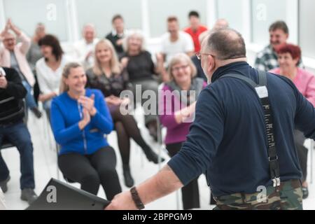 L'uomo caucasico maturo dà un discorso in riunione in ufficio aperto moderno Foto Stock