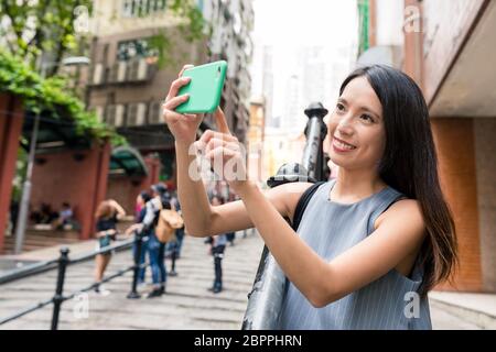 Donna prendendo foto con il cellulare in Pottinger Street Foto Stock