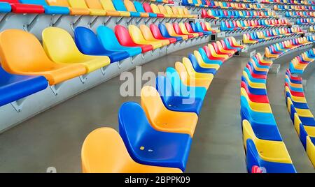 Panchine di colori diversi in uno stadio sportivo Foto Stock