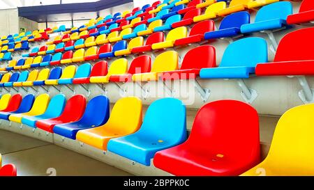 Panchine colorate in uno stadio vuoto Foto Stock