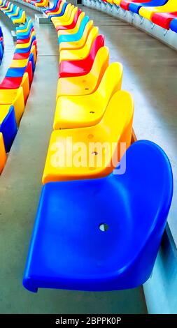 Panchine colorate in uno stadio Foto Stock