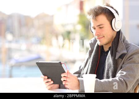 L'uomo l'e-learning guardando i tutorial online in una compressa in un coffee shop Foto Stock