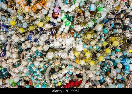 Sfondo di eleganti bracciali realizzati con pietre colorate. Falsi Gioielli. Foto Stock