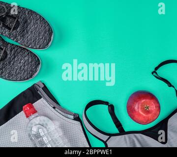 Tessuto nero scarpe e altri elementi per il fitness su uno sfondo verde, vista dall'alto Foto Stock