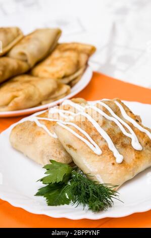 Pila di pancake con imbottitura su una piastra bianca Foto Stock