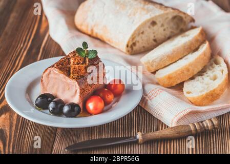 Di fegato di pollo con patè di olive nere, pomodorini e ciabatta sulla piastra bianca Foto Stock