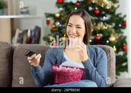 Donna di guardare la tv in natale seduto su un divano nel salotto di casa Foto Stock